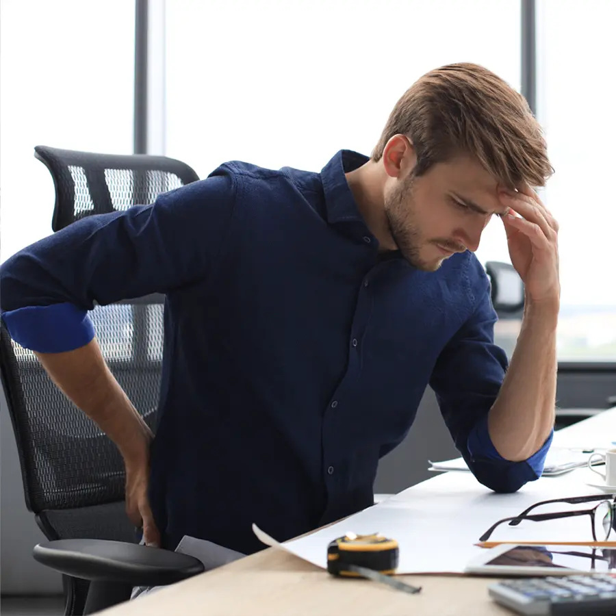 A worker who is unahppy because they need quality ergonomic office seating
