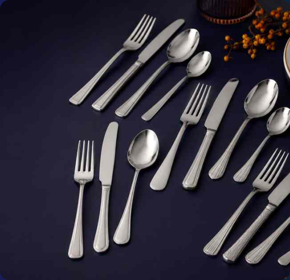 Professional GenWare stainless steel cutlery with polished forks, knives and spoons arranged on a dark blue background