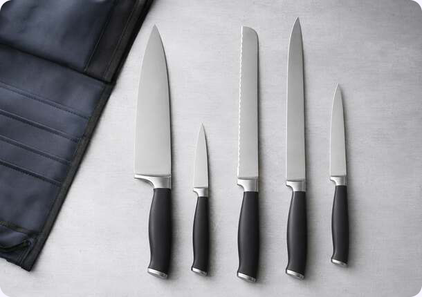 Chef knife set laid out beside a knife roll