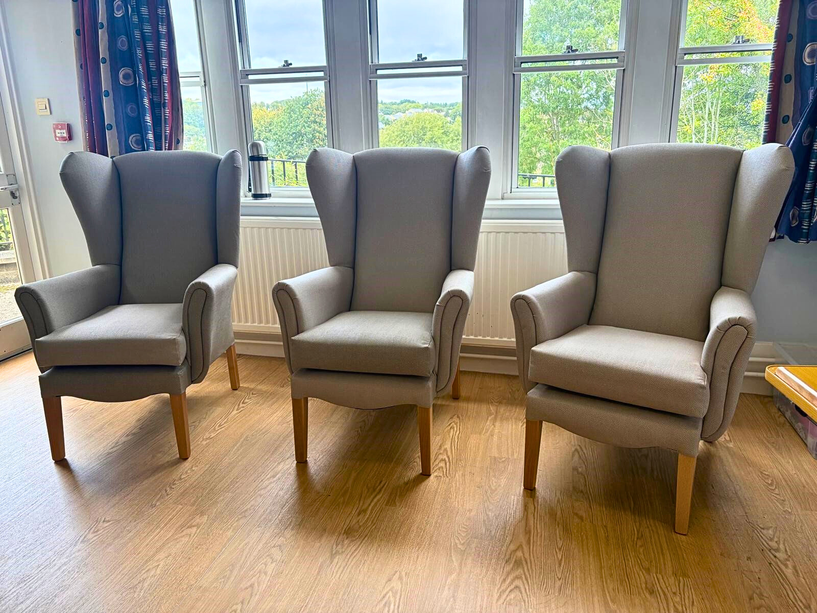 Two comfortable armchairs by a round ocffee table in a communal space