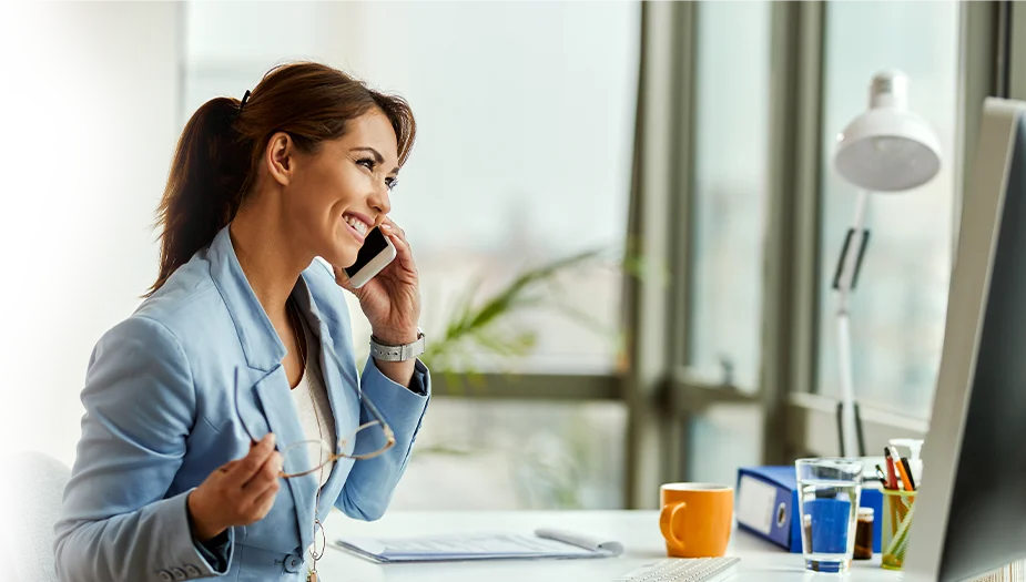 young happy businesswoman using mobile phone making phone call in office