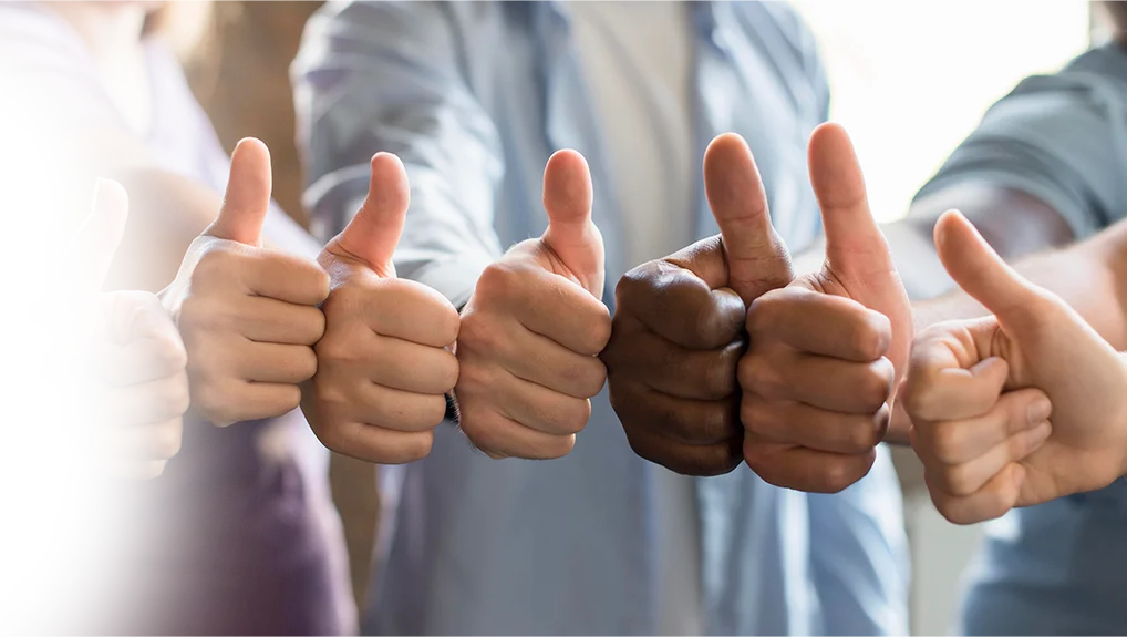group of friends gathering together with thumbs up